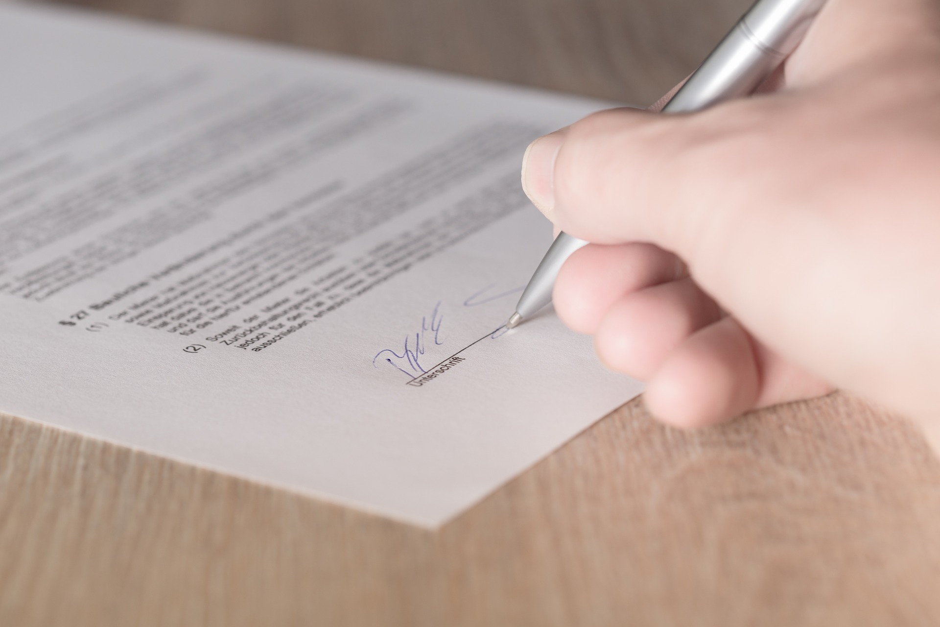 An image of person signing a contract